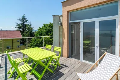 a patio with a green table and chairs on a deck at Happy-U house - Modern and with stunning view in Chernomorets