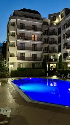 a building with a blue swimming pool in front of a building at Summer Breeze 515 Studio NO ROMANIA in Sunny Beach
