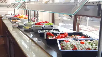 a buffet line with many dishes of food on a counter at Moreto Seaside Aparthotel in Obzor