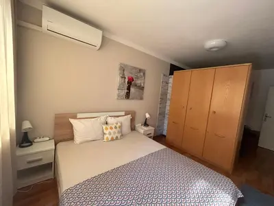 a bedroom with a bed and a dresser in it at Luxury Apartments Ani in Burgas City