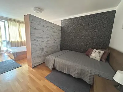 a bedroom with a bed and a wall at Luxury Apartments Ani in Burgas City