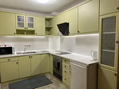 a kitchen with green and white cabinets and a sink at Luxury Apartments Ani in Burgas City