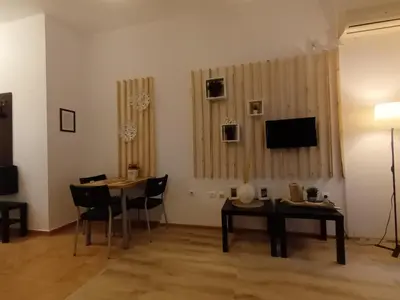 a living room with a table and chairs and a television at APARTMENT DELUXE MARINA CAPE 4 stars complex 33 6 in Aheloy