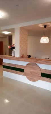 a reception desk with a wooden table in a room at Къща за гости Вивиан in Kiten