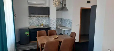 a kitchen with a table and chairs in a room at Къща за гости Вивиан in Kiten