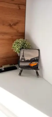 a painting of the eiffel tower sitting on a ledge at Къща за гости Вивиан in Kiten