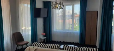 a living room with a bed and a window at Къща за гости Вивиан in Kiten