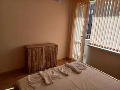 a bedroom with a bed with two towels on it at Апартамент Желева in Pomorie
