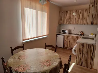 a kitchen with a table and a kitchen with a table and chairs at Апартамент Желева in Pomorie