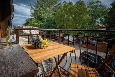 a wooden table with a bowl of fruit on a balcony at Къща за гости Димови in Sozopol