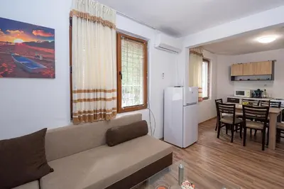 a living room with a couch and a kitchen with a table at Къща за гости Димови in Sozopol