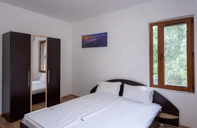a bedroom with a bed and a mirror in it at Къща за гости Димови in Sozopol