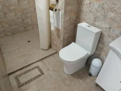 a bathroom with a white toilet and a sink at Къщата с разкопките - The house with the excavations in Sozopol