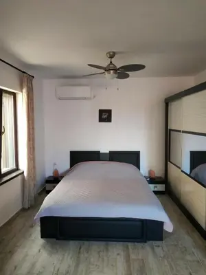 a bedroom with a bed and a ceiling fan at Къщата с разкопките - The house with the excavations in Sozopol