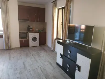 a living room with a tv and a kitchen at Къщата с разкопките - The house with the excavations in Sozopol