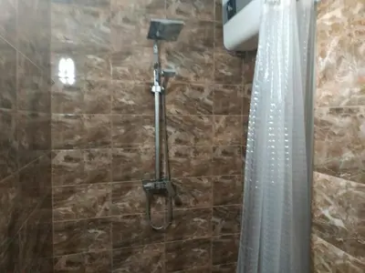 a shower in a bathroom with a shower curtain at Къщата с разкопките - The house with the excavations in Sozopol