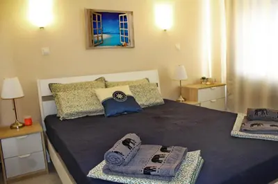 a bedroom with a large bed with towels on it at Pomorie Residence 1-bedroom apartment with pool & free parking, 300 m to the beach in Pomorie