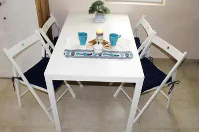 a white table and chairs with a candle on it at Pomorie Residence 1-bedroom apartment with pool & free parking, 300 m to the beach in Pomorie