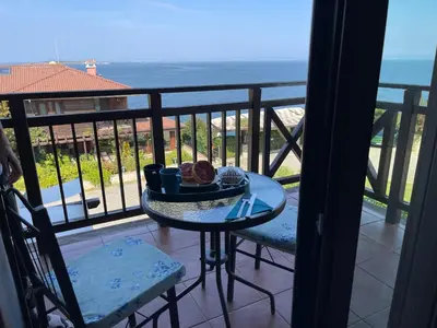 a table with a plate of food on a balcony at Sozopolis Cliffs Luxury Seaview Villa in Sozopol