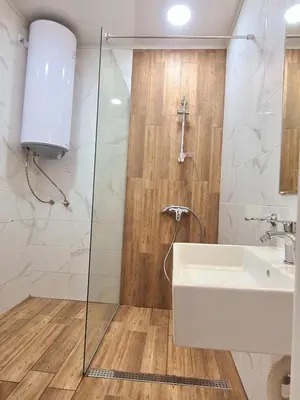 a bathroom with a sink and a glass shower at Dolphin beach apart Obzor in Obzor