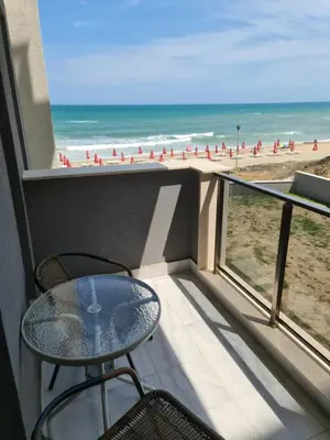 a balcony with a table and chairs and the beach at Dolphin beach apart Obzor in Obzor