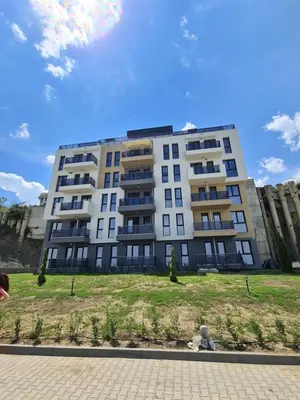 a large white building with a grass field in front of it at Dolphin beach apart Obzor in Obzor