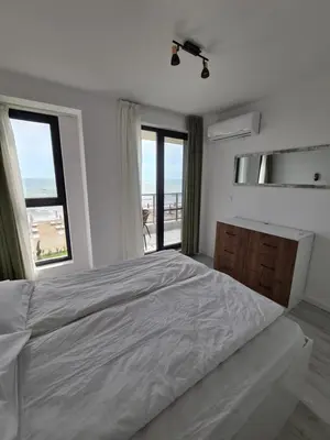 a bedroom with a large bed with a view of the ocean at Gold beach apart Obzor in Obzor