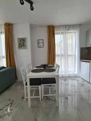 a white table and chairs in a living room at Gold beach apart Obzor in Obzor
