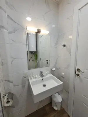 a white bathroom with a sink and a mirror at Gold beach apart Obzor in Obzor
