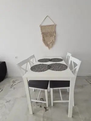 a white table with two chairs and a wall at Cactus beach apart Obzor in Obzor