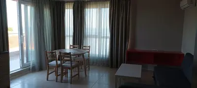 a dining room with a table and chairs and windows at Swan Bay complex in Chernomorets