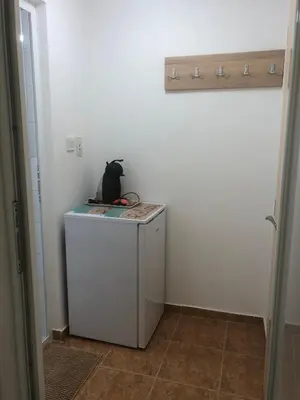 a cat sitting on top of a washing machine in a room at Borko Guest House in Primorsko