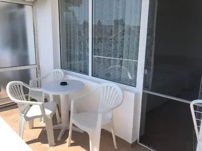 a small table and chairs in a room with a window at Borko Guest House in Primorsko