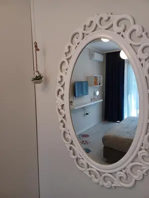 a mirror reflecting a bedroom with a bed in a room at Tara Deluxe Apartment in Varna City