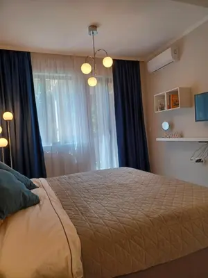a bedroom with a bed and a window at Tara Deluxe Apartment in Varna City