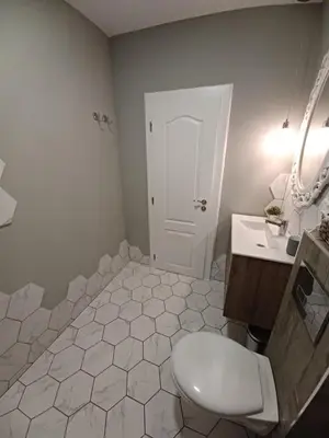 a white bathroom with a toilet and a sink at Tara Deluxe Apartment in Varna City