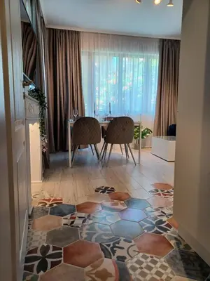 a living room with a table and two chairs and a floor at Tara Deluxe Apartment in Varna City