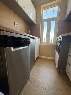 a kitchen with a stainless steel refrigerator and a window at Chernomorets Apartment in Chernomorets