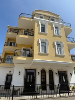 a yellow building with windows and a fence at Chernomorets Apartment in Chernomorets