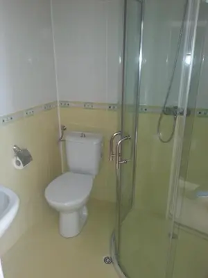 a bathroom with a toilet and a glass shower at Hotel Ray in Sozopol