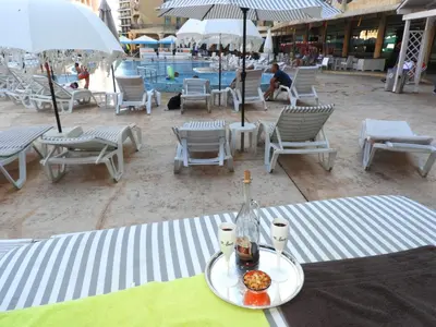 a plate of food on a table next to a pool at Sunrise Studio Grenada in Sunny Beach
