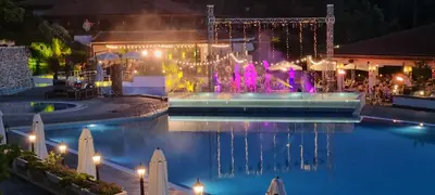 a pool with a fountain at night with lights at Eve Santa Marina Studios - sea, pools, relax in Sozopol