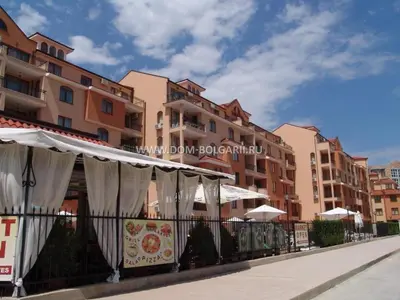 a row of buildings with white umbrellas on a street at Holidays apartment Kassandra Sunny Beach in Sunny Beach
