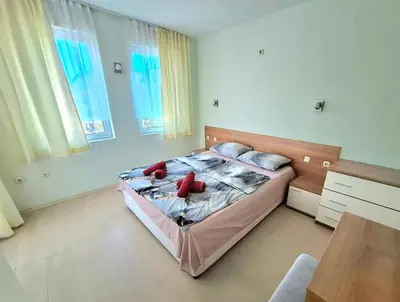 a bedroom with a bed with red pillows on it at Sunset Dream Polo Resort in Sunny Beach