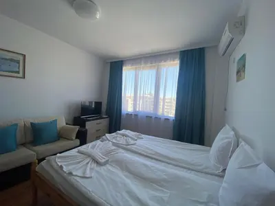 a bedroom with a bed and a couch and a window at SUMMER BREEZE 503 Private Studio SUNNY BEACH in Sunny Beach