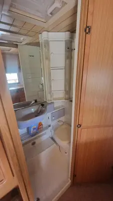 a small bathroom with a sink and a toilet at Каравана Амалтея in Sozopol