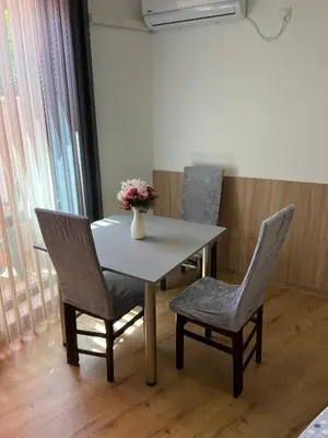 a table and chairs with a vase of flowers on it at Студио ''Сарафово'' на първа линия in Burgas City