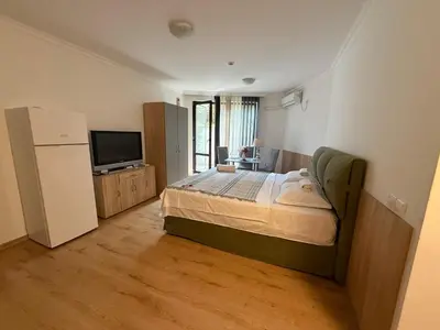 a bedroom with a large bed and a television at Студио ''Сарафово'' на първа линия in Burgas City