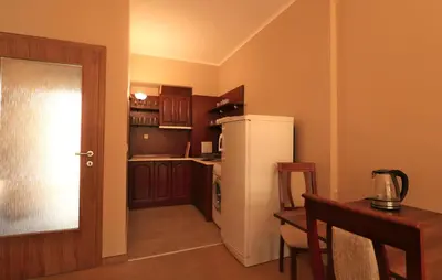 a small kitchen with a refrigerator and a table at Първа линия Апартаменти in Pomorie