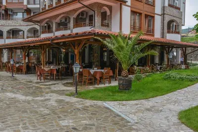 a restaurant with tables and chairs in front of a building at Luxe Apartment Olymp in Sveti Vlas in Sveti Vlas